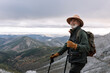 © Sergio Victor Vega/ADDICTIVE STOCK - Delighted senior male traveler in warm clothes and with trekking poles standing in highlands and looking away during vacation in Caceres