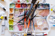 © The Trio Studio/ADDICTIVE STOCK - High angle multicolored paintbrushes of different sizes placed on watercolor palette