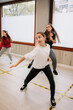 © Raquel Arocena/ADDICTIVE STOCK - Group of young women and girls rehearsing hip hop dancing movements while practicing in spacious hall together during active lesson with instructor