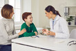 © Studio Romantic - Friendly pediatric dentist consults mother with her young son in the office of a modern dental clinic. Mother and child discuss dental treatment plan. Concept of painless treatment of children's teeth