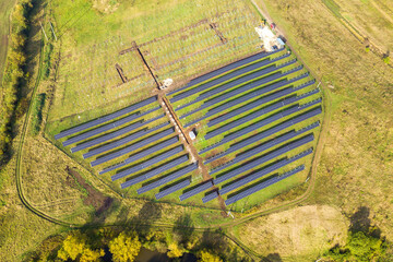 Aerial view of solar power plant under construction on green field. Assembling of electric panels for producing clean ecologic energy.