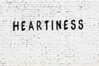 Inscription heartiness painted on white brick wall