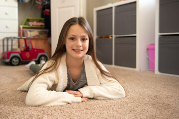 Beautiful tween girl lying on the floor of her bedroom.