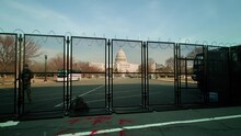 A Time-lapse Of The Security Perimeter, Manned By National Guard Troops, In Front Of The U.S. Capitol Building At Sunset. The Fence Was Erected Following The January 6 Riot. The Camera Tracks Left.