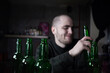 © Матвей Саливанчук - A photo of a young depressed drunk man drinking beer from a bottle, at home, brooding and confused, like an alcoholic, suffering from the problem of alcoholism and alcohol addiction