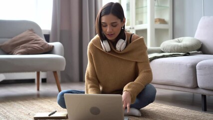 Canvas Print - Attractive Indian mixed-race woman is sitting on the floor and using laptop