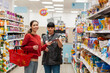 © _KUBE_ - A sales consultant in a supermarket offers the buyer a profitable product for the promotion. Young women of Caucasian nationality. The concept of shopping and business