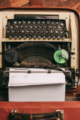 Fototapete - vintage typewriter with white paper stands on the floor indoors top view