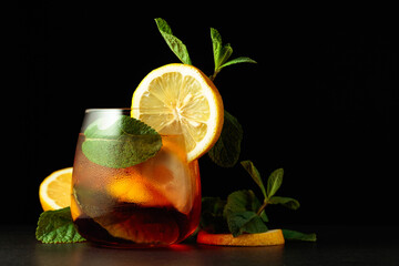 Cold refreshing summer cocktail Cuba libre with lemon slices and mint.