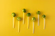 Set of brussel sprouts with lollipop sticks on yellow background	