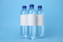 Plastic Bottles With Soda Water On Light Blue Background