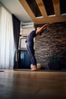 © chika_milan - A woman practicing yoga at home. A woman in mountain yoga pose.