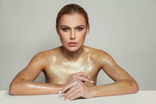 Fashion Model Woman In Golden Glitter Shimmer Posing On White Background