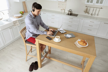 Poster - Businessman in shirt and underwear working on laptop at home