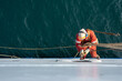 © Denys Yelmanov  - Seaman ship crew working aloft at height derusting and getting vessel ready for painting.