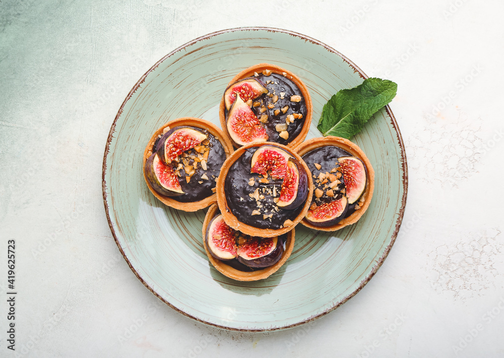 Tartlets with tasty chocolate paste and figs on table