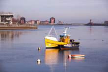 Bright Yellow Fishing Boat In Port Of Sunderland On The River Wear Casts Its Reflection On To The Still Waters