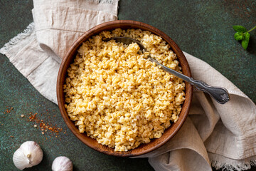 Sticker - Cooked bulgur in a bowl on a dark background top view. Copy space for text. Turkish cuisine, vegan food.