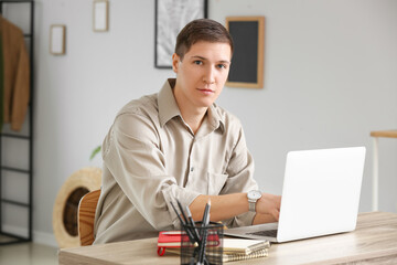 Handsome young man using laptop at home