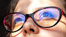 Close Up Of Woman's Eyes With Red And Black Female Glasses For Working At A Computer With A Blue Filter Lenses. Anti Blue Light And Rays. Eye Protection