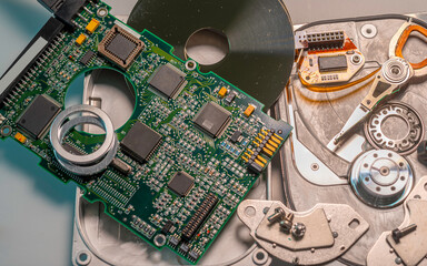  Internal hard disk completely disassembled. Note the head reading data from the disk and the integrated circuits mounted on a card