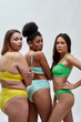 © Svitlana - Three multiethnic young women with different body shapes in colorful underwear turning their heads to camera, posing isolated over light background