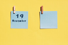 19 November. 19th Day Of The Month, Calendar Date. Two Blue Sheets For Writing On A Yellow Background. Top View, Copy Space. Autumn Month, Day Of The Year Concept