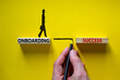 Onboarding success symbol. Wooden blocks with words 'onboarding success'. Businessman hand. Businesswoman icon. Beautiful yellow background, copy space. Business and onboarding success concept.