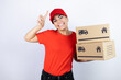 © Irene - Young beautiful woman wearing courier uniform holding delivery packages smiling, looking at the camera and pointing up with finger and raised arm