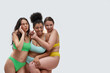 © Svitlana - Three multiethnic young women in colorful underwear looking happy, having fun while posing together isolated over white background