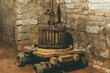 Photo of an old vintage wooden winepress near in a big stone cellar.