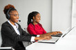 two beautiful african young women in the office at the table with a laptop 