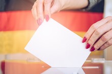 Woman Voting On Elections In Gemany. Flag Germany On Background.
