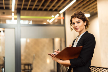 Portrait of a successful entrepreneur holding a contract and a pen.