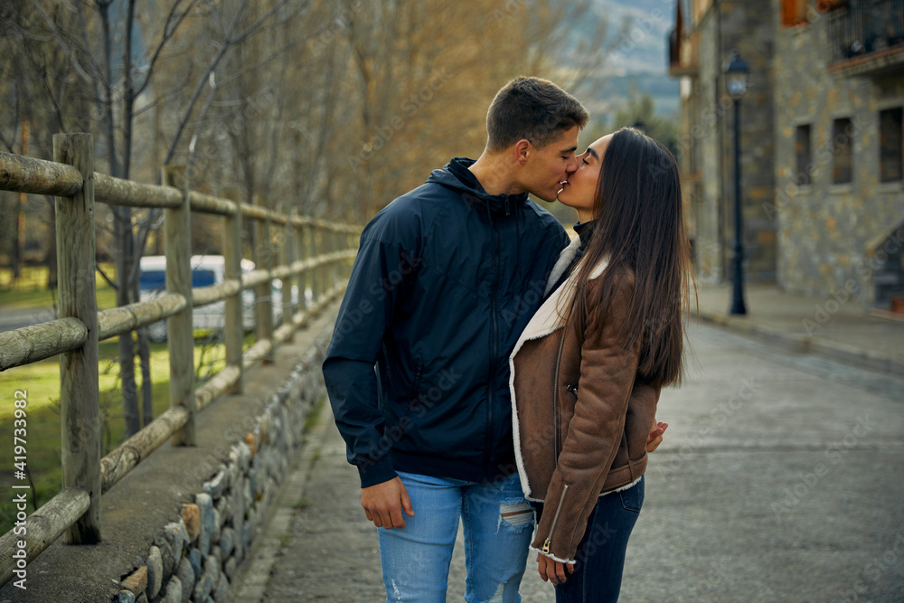 Girlfriend and boyfriend kissing passionately with eyes closed in town ...