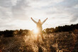 © VITTA GALLERY/Westend61 - Senior male hiker with arms raised standing in filed during sunset