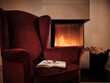 © Dirk Kittelberger/Westend61 - Eyeglasses with open book on maroon wingback chair by fireplace at home