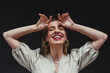 © MORNINGVIEW AGENCY/Westend61 - Carefree woman with arms raised against black background