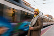 © Ezequiel Gim√©nez/Westend61 - Mid adult man wearing knit hat holding coffee cup while standing at station