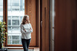 © Joseffson/Westend61 - Female entrepreneur with arms crossed looking through window in office