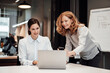 © Joseffson/Westend61 - Happy businesswoman discussing with female colleague at conference table during meeting in office