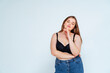 © OneInchPunch/Westend61 - Confident curvy woman wearing bra and jeans standing against white background