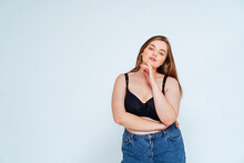 Confident Curvy Woman Wearing Bra And Jeans Standing Against White Background