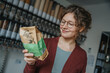 © Mareen Fischinger/Westend61 - Smiling young woman reading label on package in zero waste shop