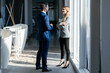 © JOSEP SURIA/Westend61 - Smiling businesswoman talking to colleague while standing in office