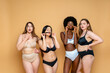 © OneInchPunch/Westend61 - Multi-ethnic group of female models in lingerie standing against yellow background