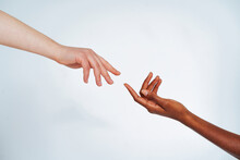 Friends Stretching Hands Toward Each Other Against White Background