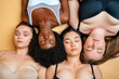 © OneInchPunch/Westend61 - Young women wearing lingerie resting while lying on yellow background