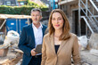 © peter scholl/Westend61 - Businesswoman smiling while standing with colleague at construction site