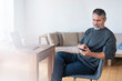 © steve brookland/Westend61 - Mature businessman using mobile phone while sitting at home office